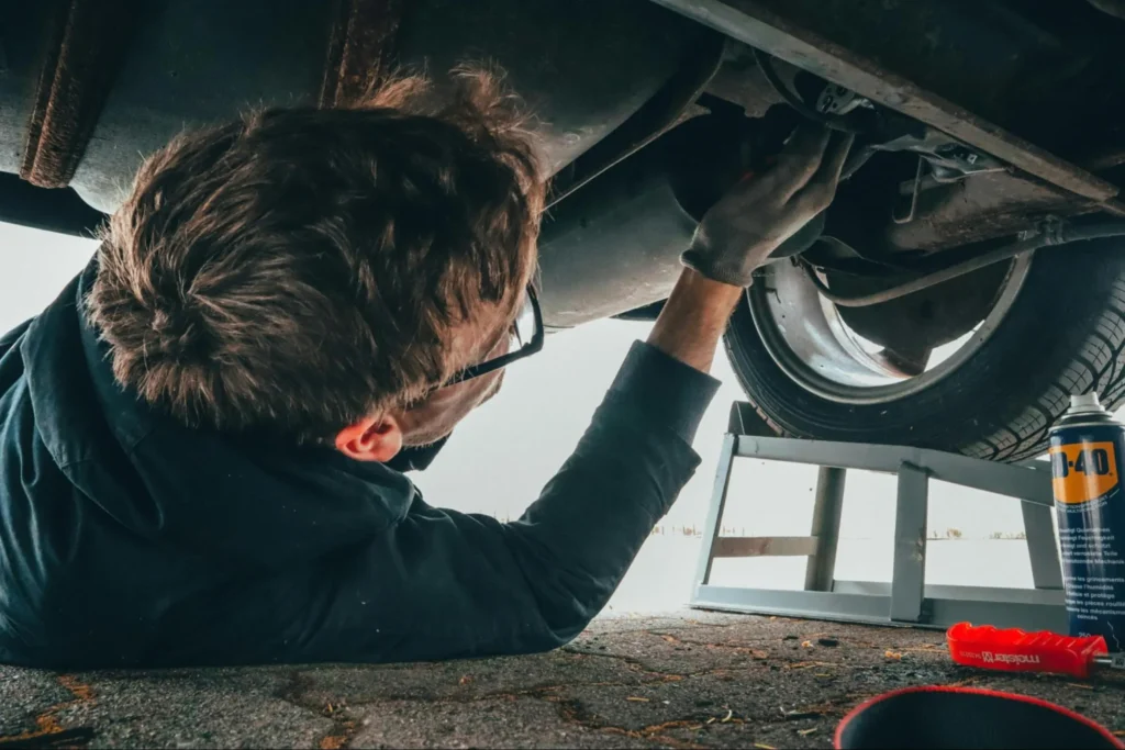 Image of a mechanic working on a car within the automotive industry.