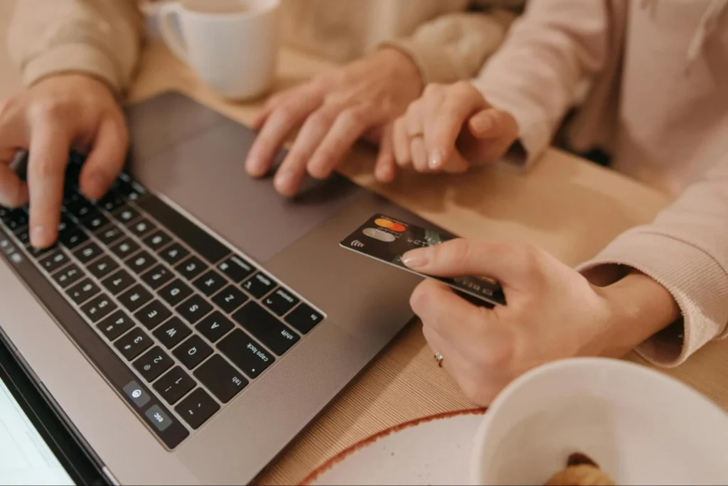 Two people using a credit card to purchase goods and services over the Internet.