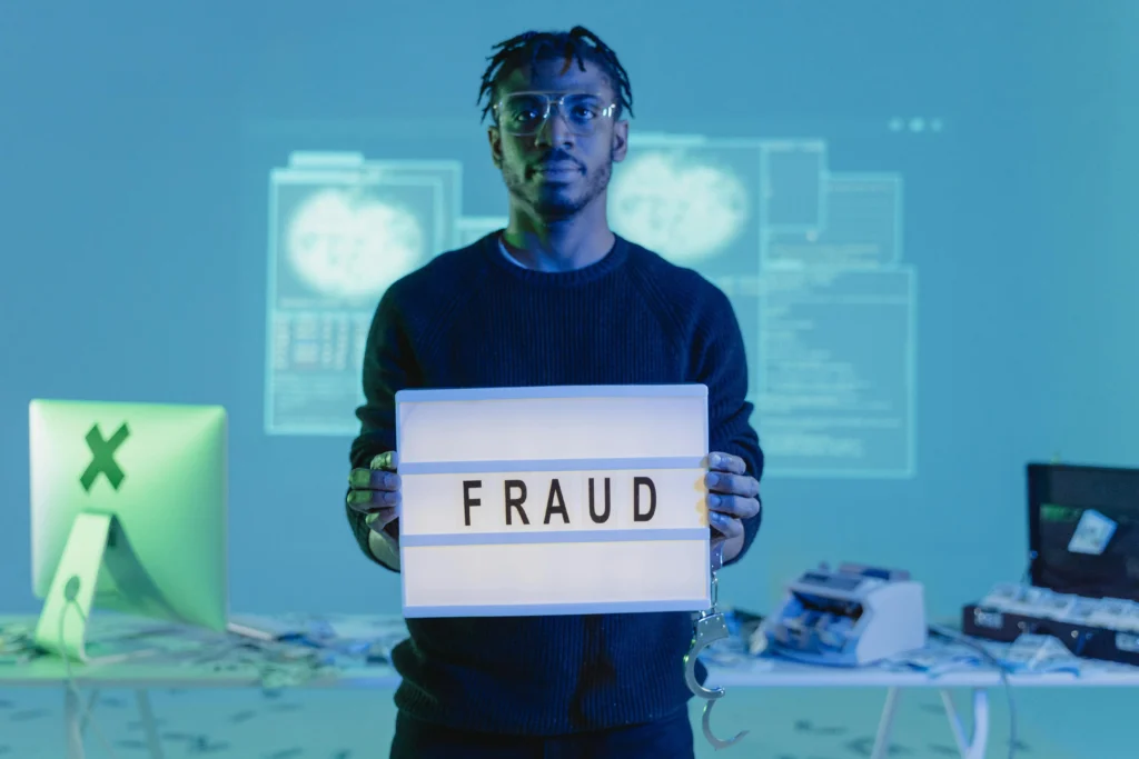 A man holding a sign representing the prevalence of online fraud tactics.