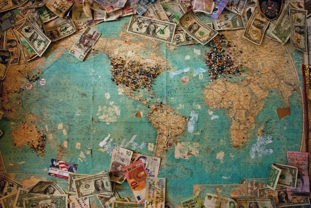 A world map surrounded by money, representing cross border AML compliance issues.