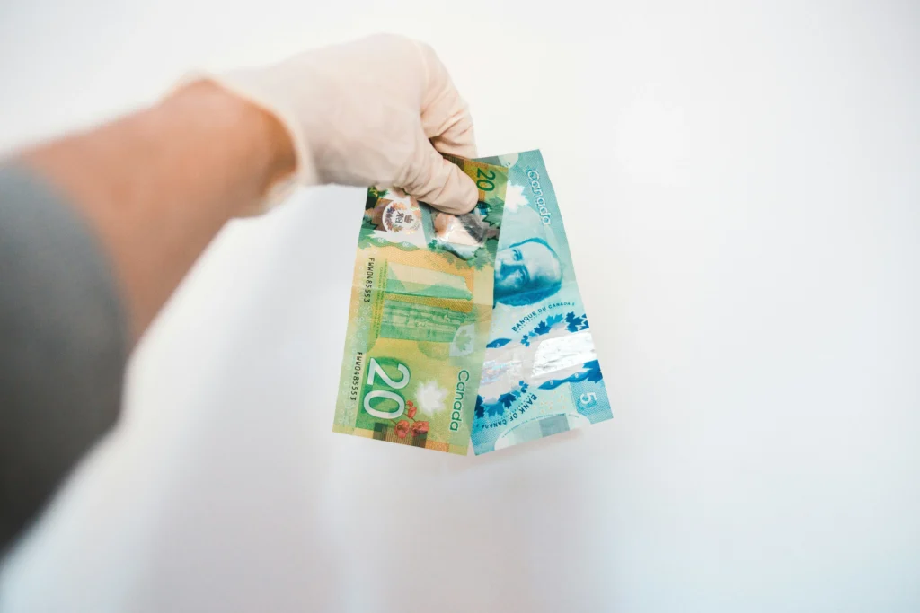 An employee holding money, representing the human intervention required in AML compliance.