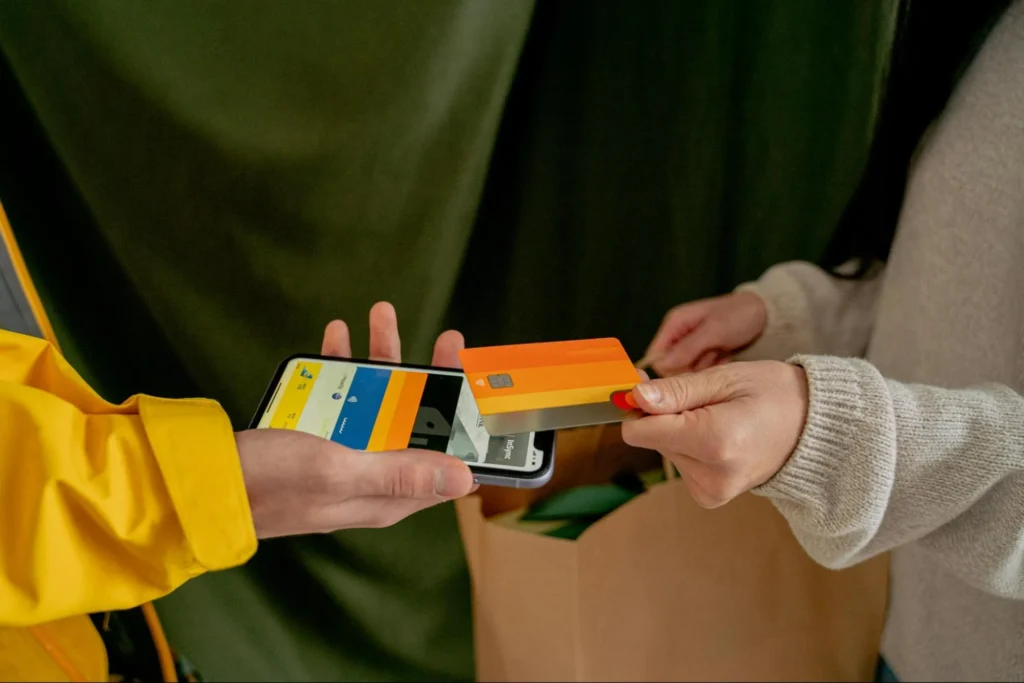 A customer paying by credit card on a mobile device, highlighting the diverse range of sub-merchants PayFacs have.