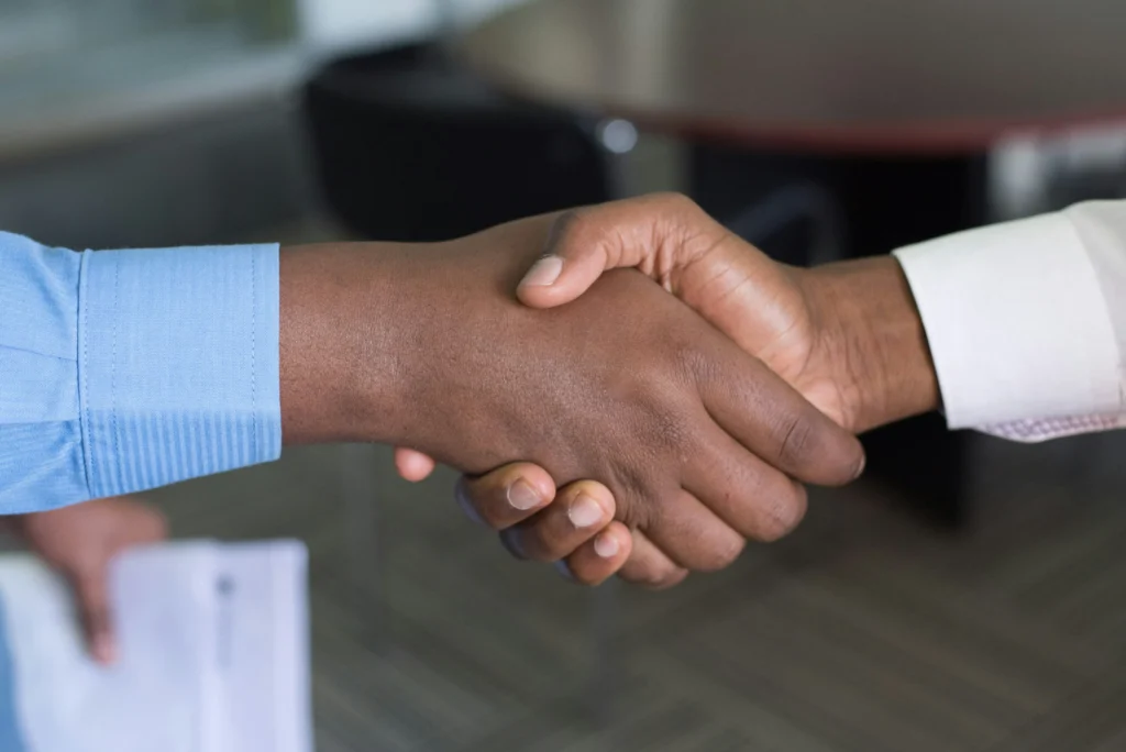 A customer and business owner shaking hands, having solved a dispute.