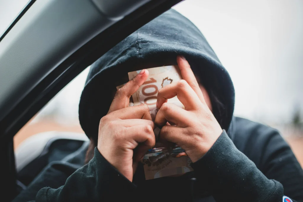 A fraudster looking at the money they’ve made from criminal activities.