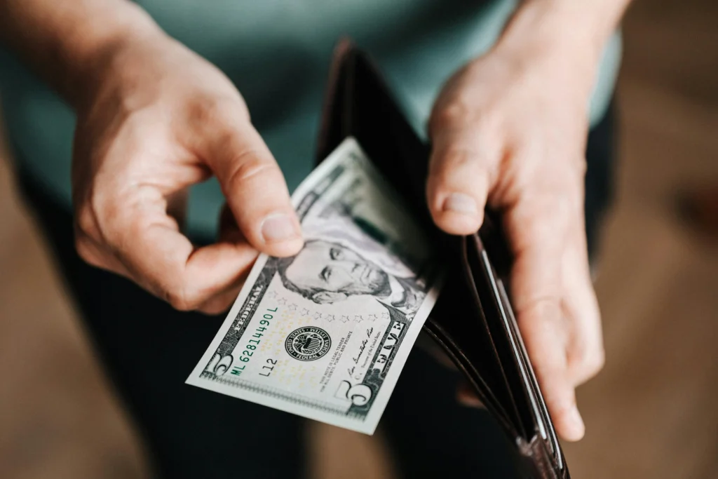 A man emptying his wallet due to excessive interchange fees.