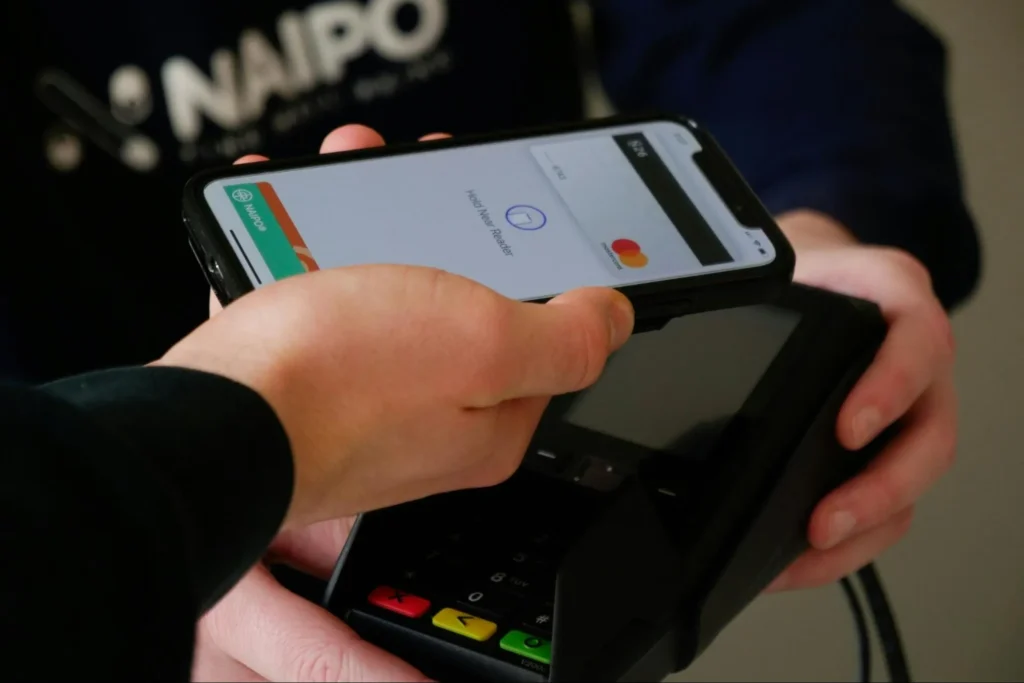 A person paying with a mobile wallet for goods and services bought in-store.